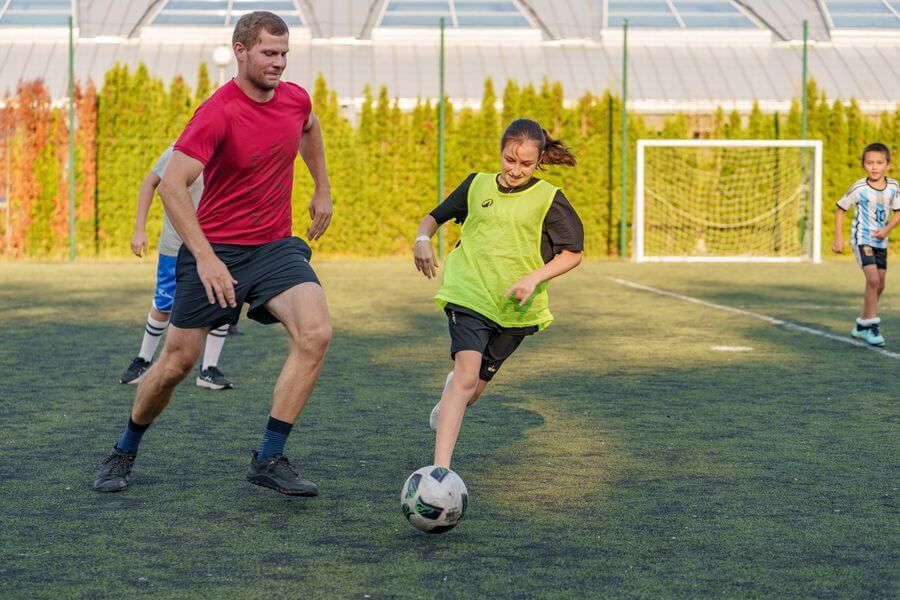 A coach and a young player on the pitch
