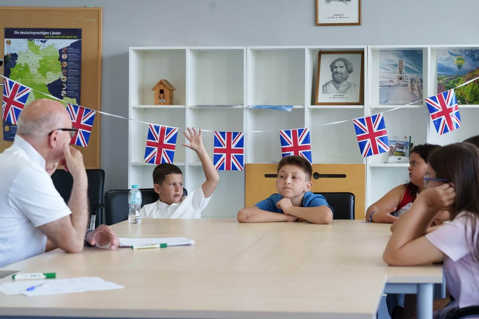 A child raising a hand and speaking in an English lesson at a summer camp
