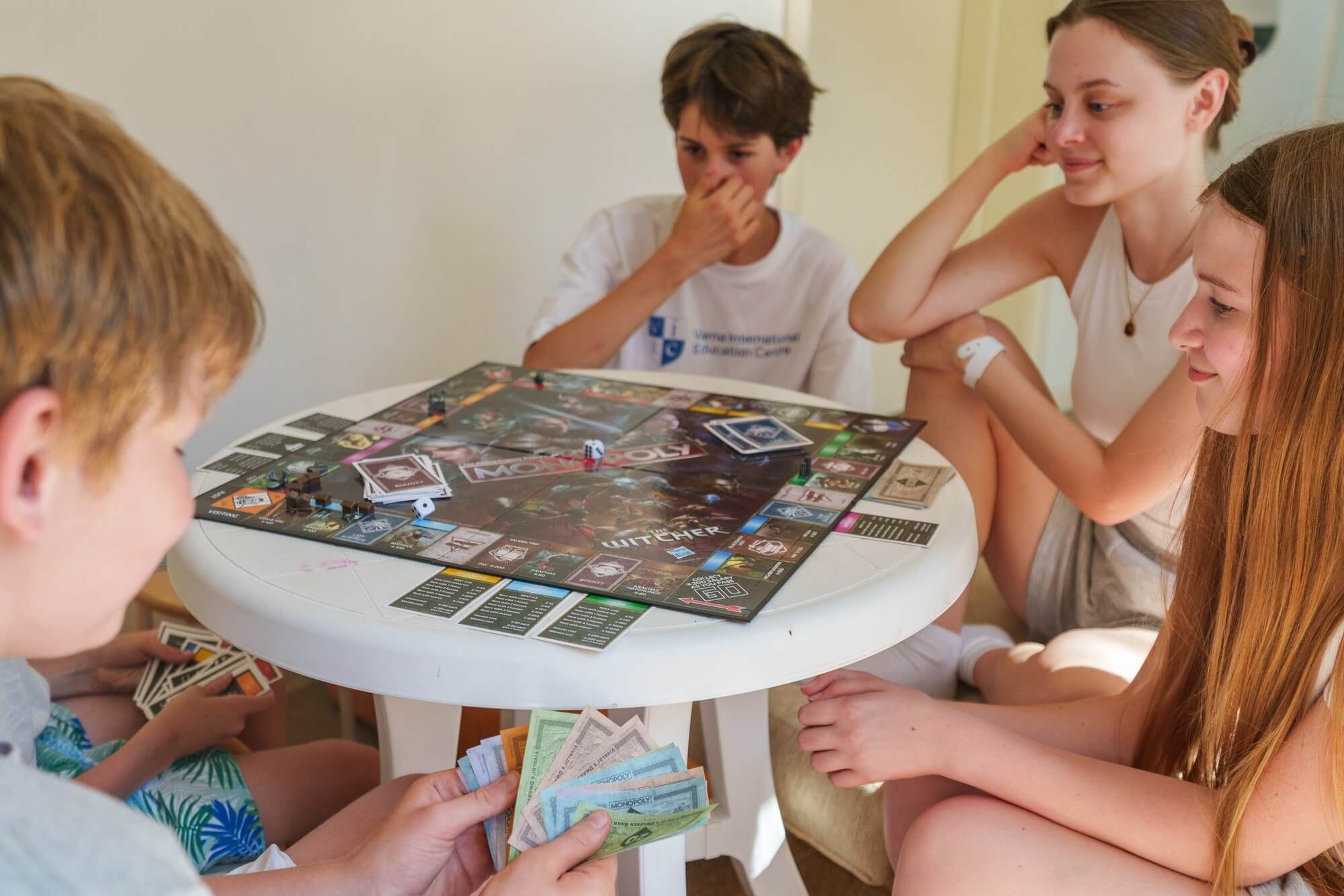 Teenagers playing a board game together in the evening at VIEC summer camp