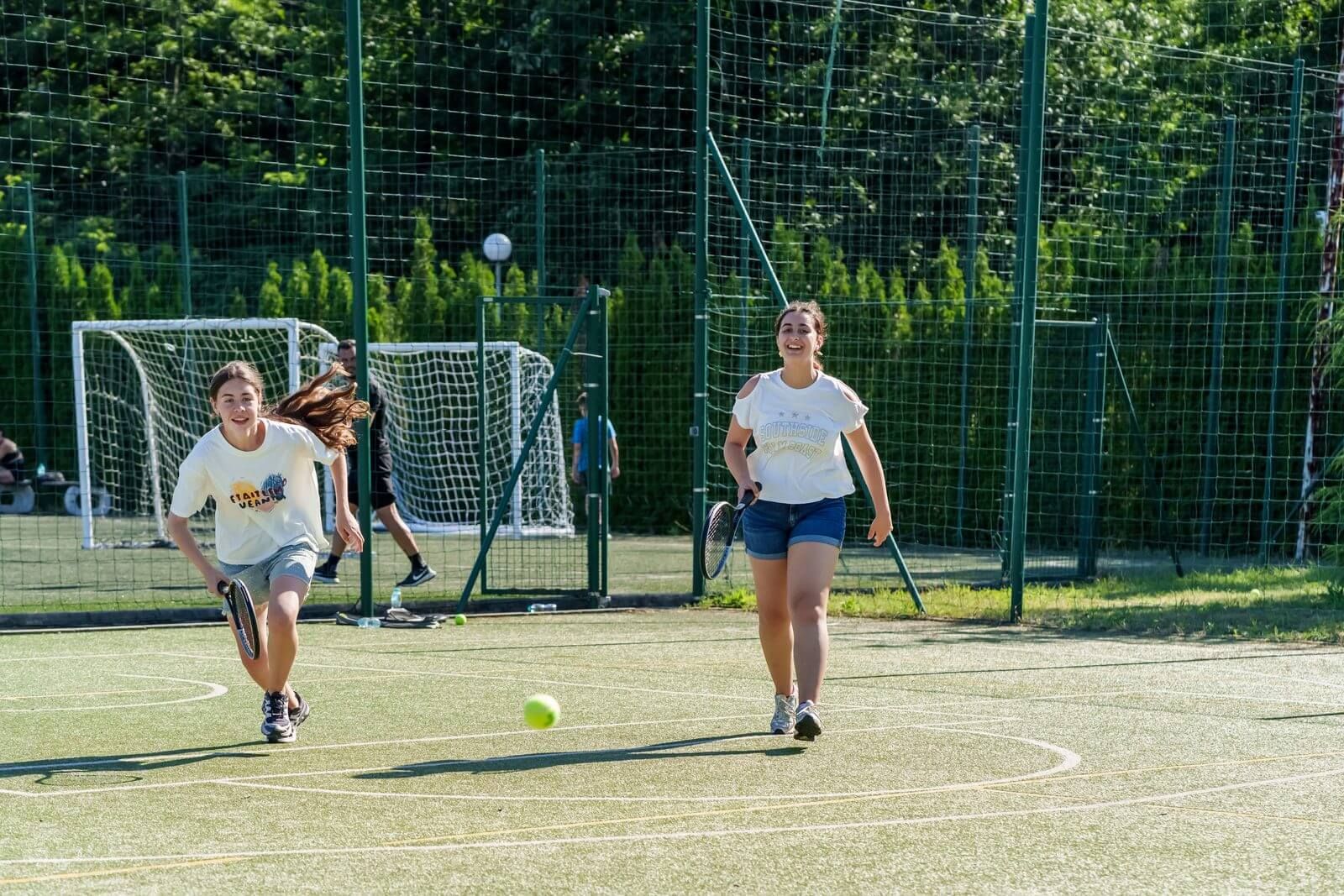 Children playing tennis on the sports court at a summer camp in Europe